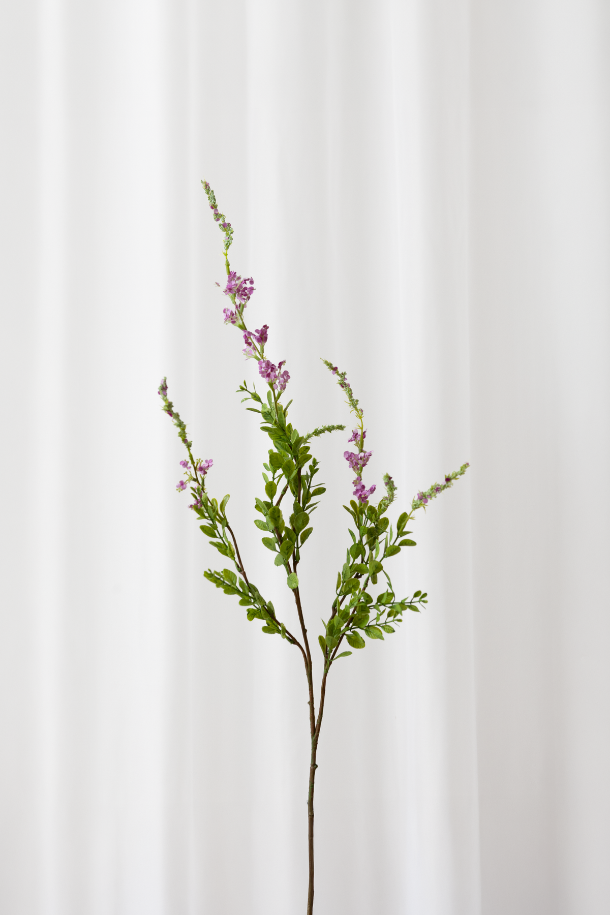 Naturtro kunstig sage gren med lilla/pink blomster og grønne blade med høj detaljegrad.