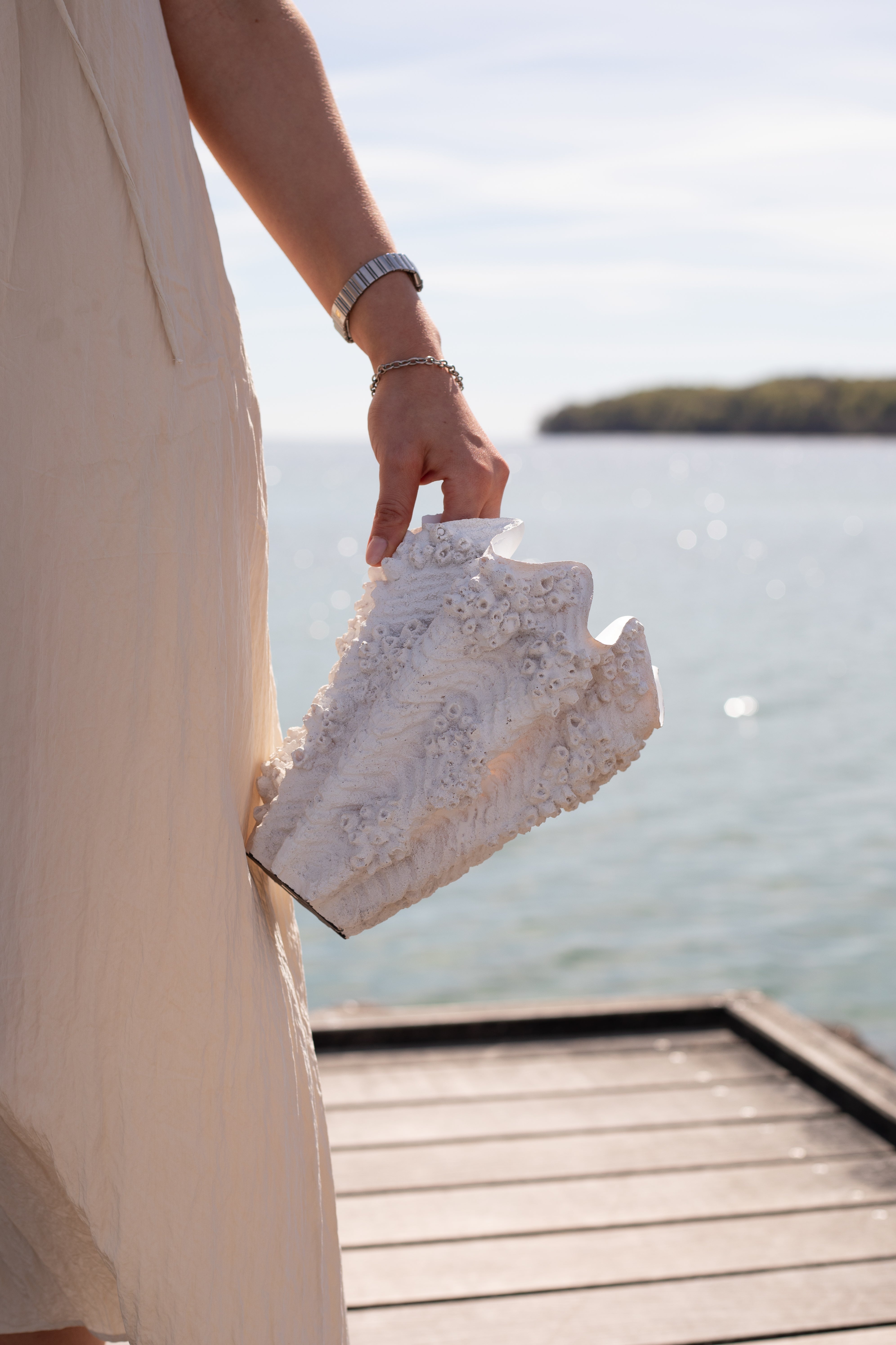 Naya vasen fotograferet ved vandet. Vasen og dens detaljer er inspireret af havet, stranden og muslinger.