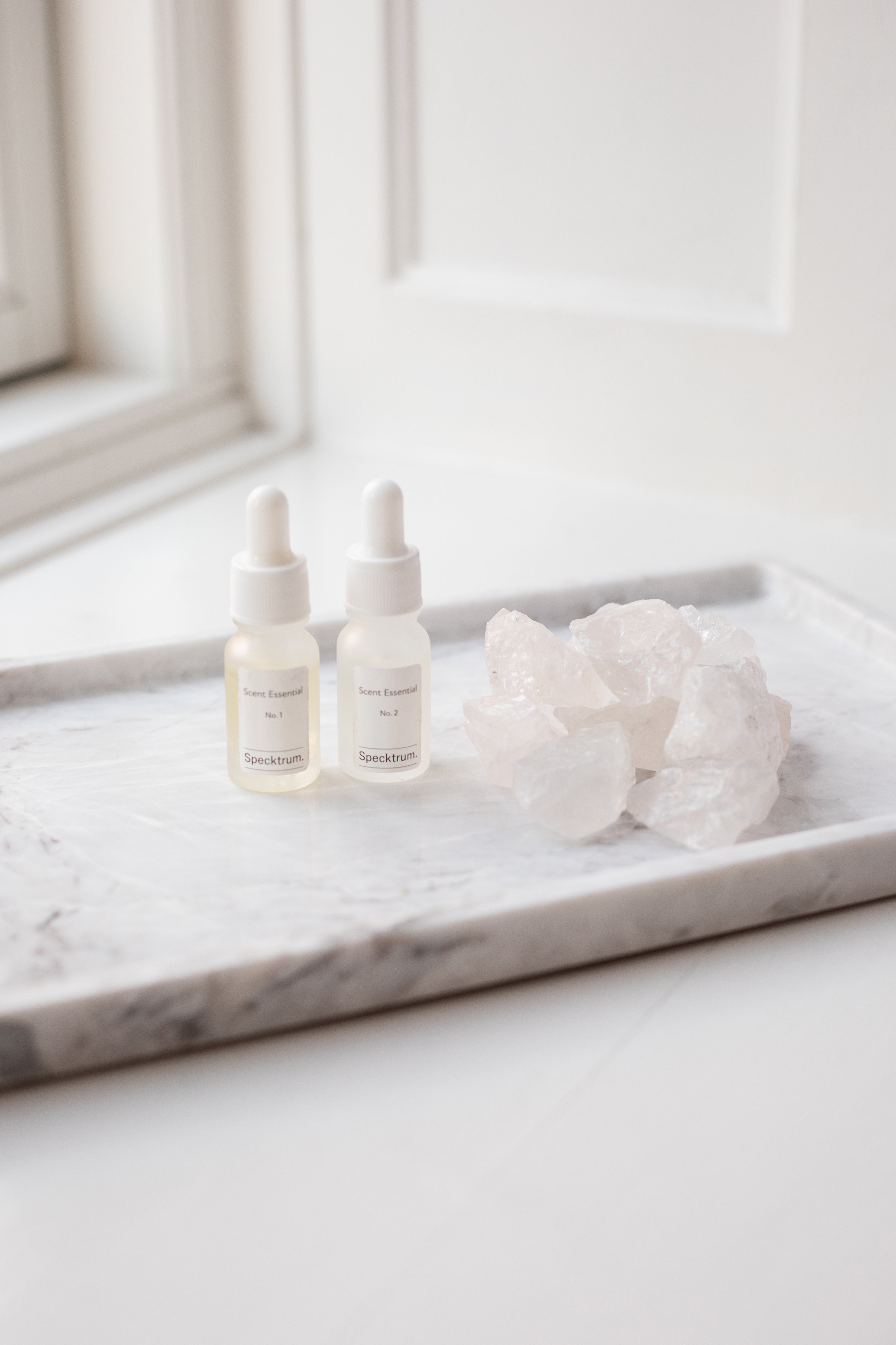 Krystal sten i hvid, der ligger på en marmor bakke med Specktrum duft scent