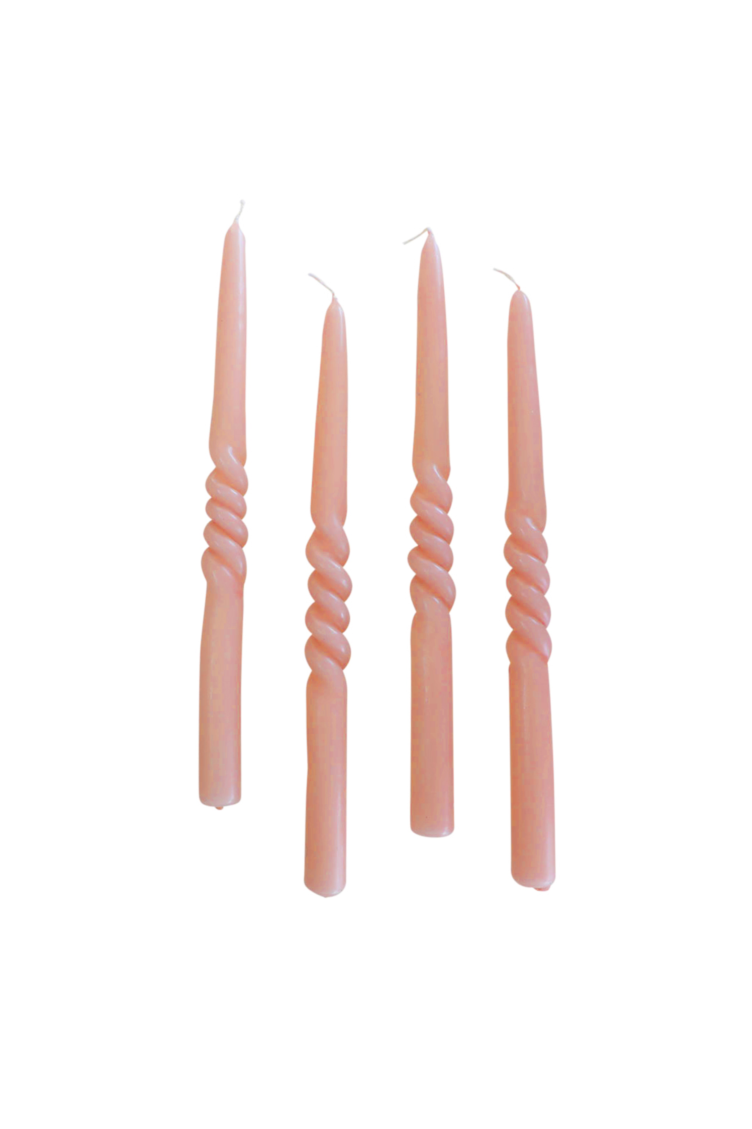Fire snoede stagelys i en støvet rosa farve placeret oprejst mod en hvid baggrund.