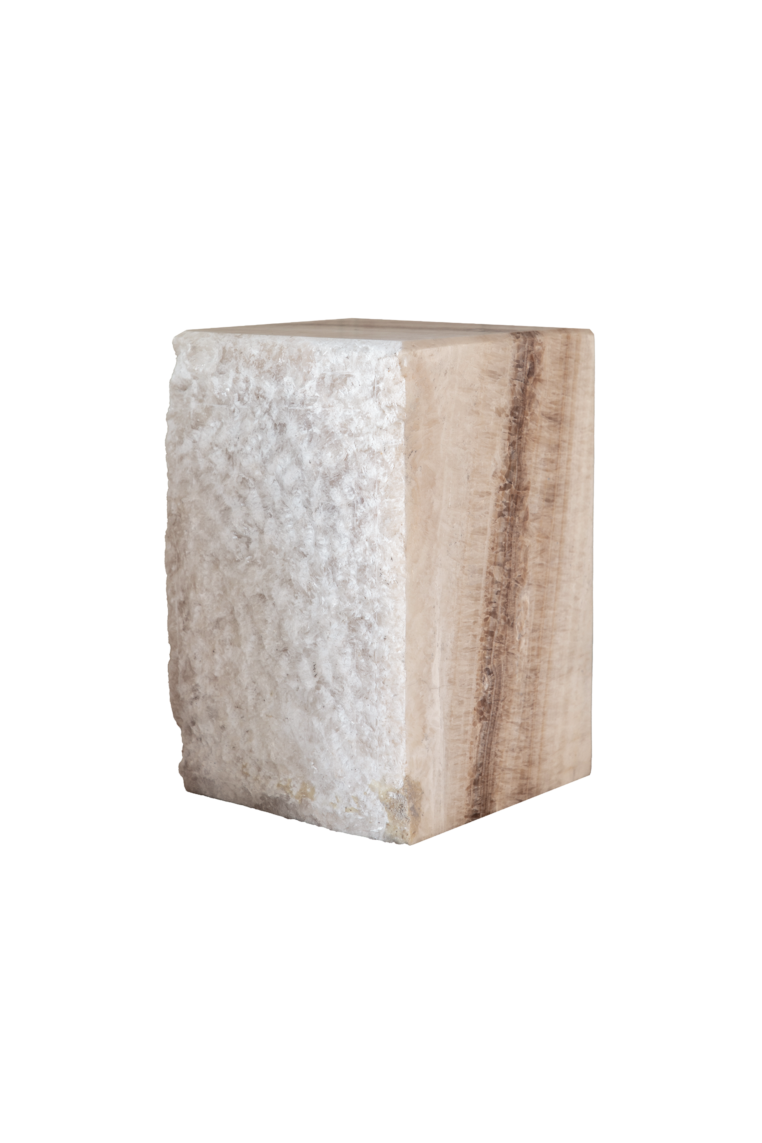Kubisk blok af natursten i lyse beige og hvide nuancer med en rå, ujævn overflade på den ene side og glattere slebne flader på de andre.
