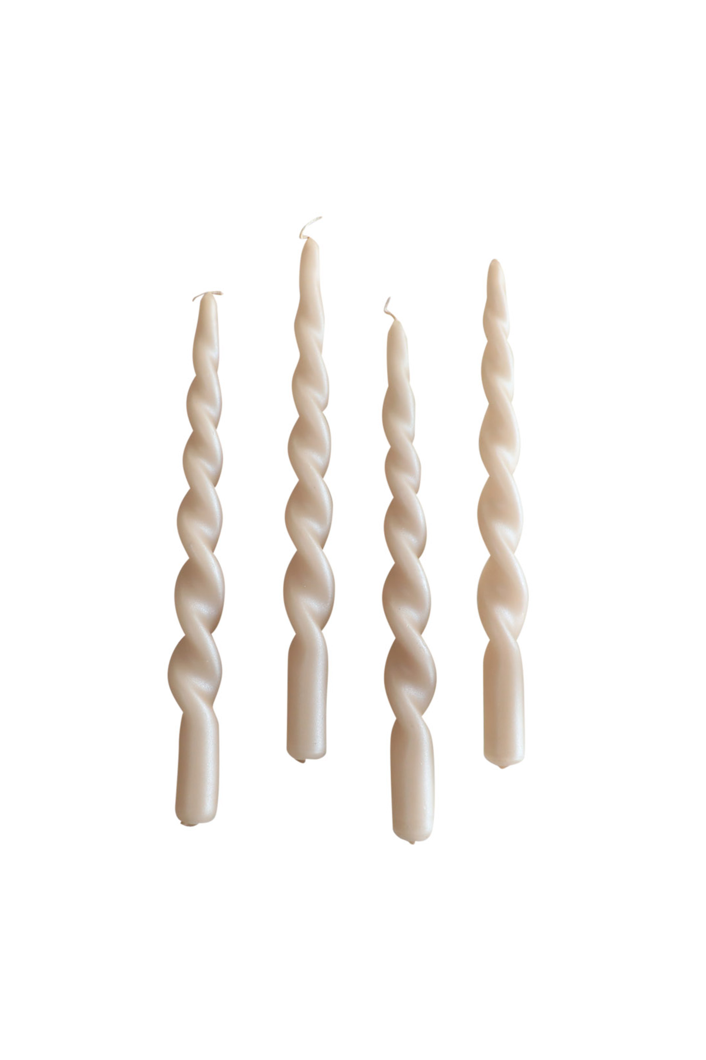 Fire snoede stagelys i farven Nude Pearl placeret lodret side om side på hvid baggrund.
