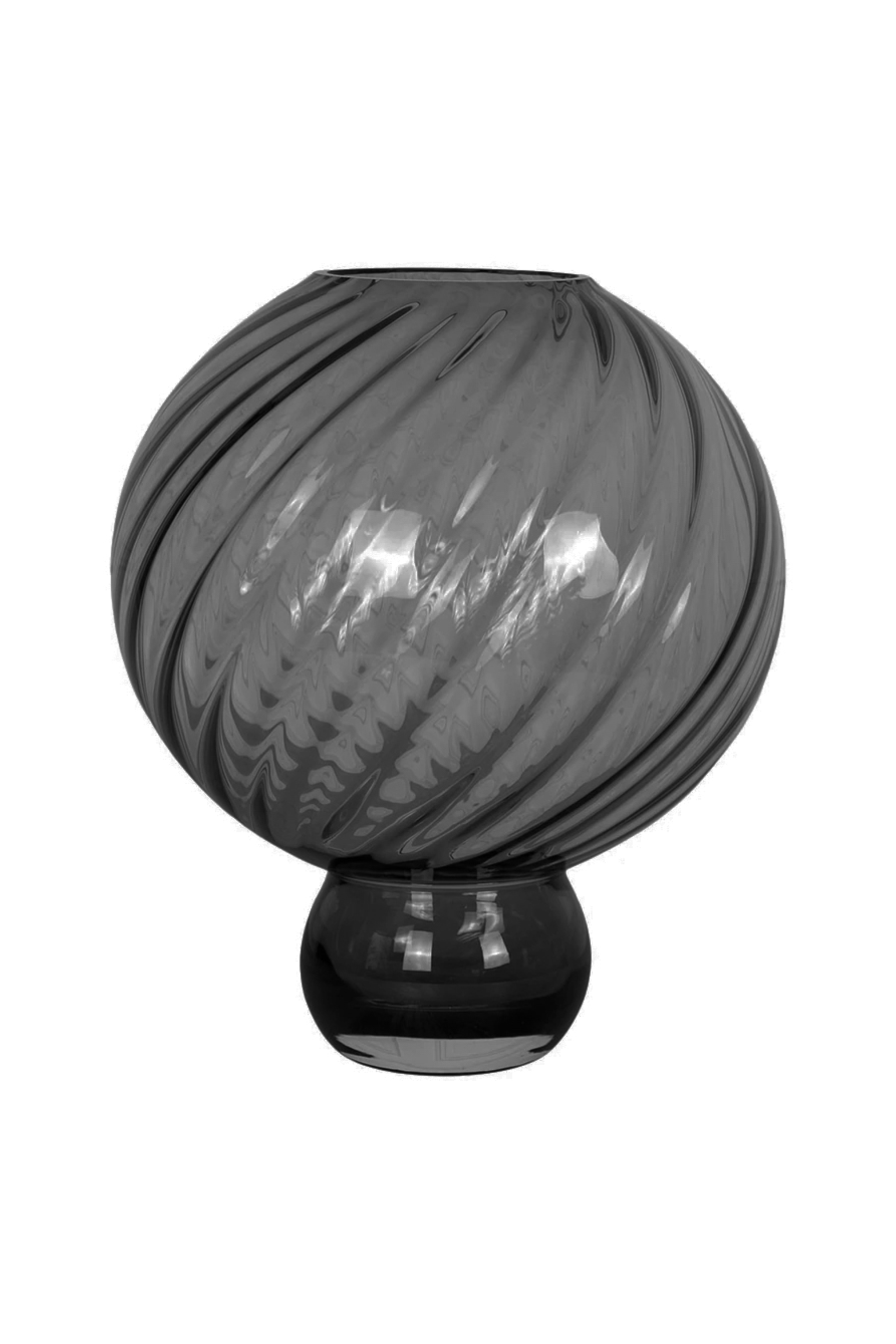 Røgfarvet glasvase med rund, svunget krop og drejede riller, stående på en smal, rund fod. Vasen har en blank, gennemsigtig overflade, hvor lyset reflekteres.