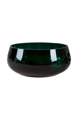 Rund skål i mørkegrønt glas med blank overflade. Skålen har en enkel, lav form med bløde kurver og en glansfuld finish, der fremhæver glasset.