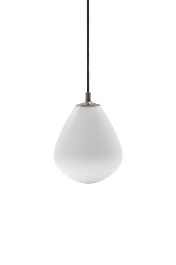 En enkelt pendellampe med en mat hvid, dråbeformet glasskærm. Lampen hænger fra en sort stofledning og har en lille metalfatning i mørk finish. Baggrunden er hvid og neutral