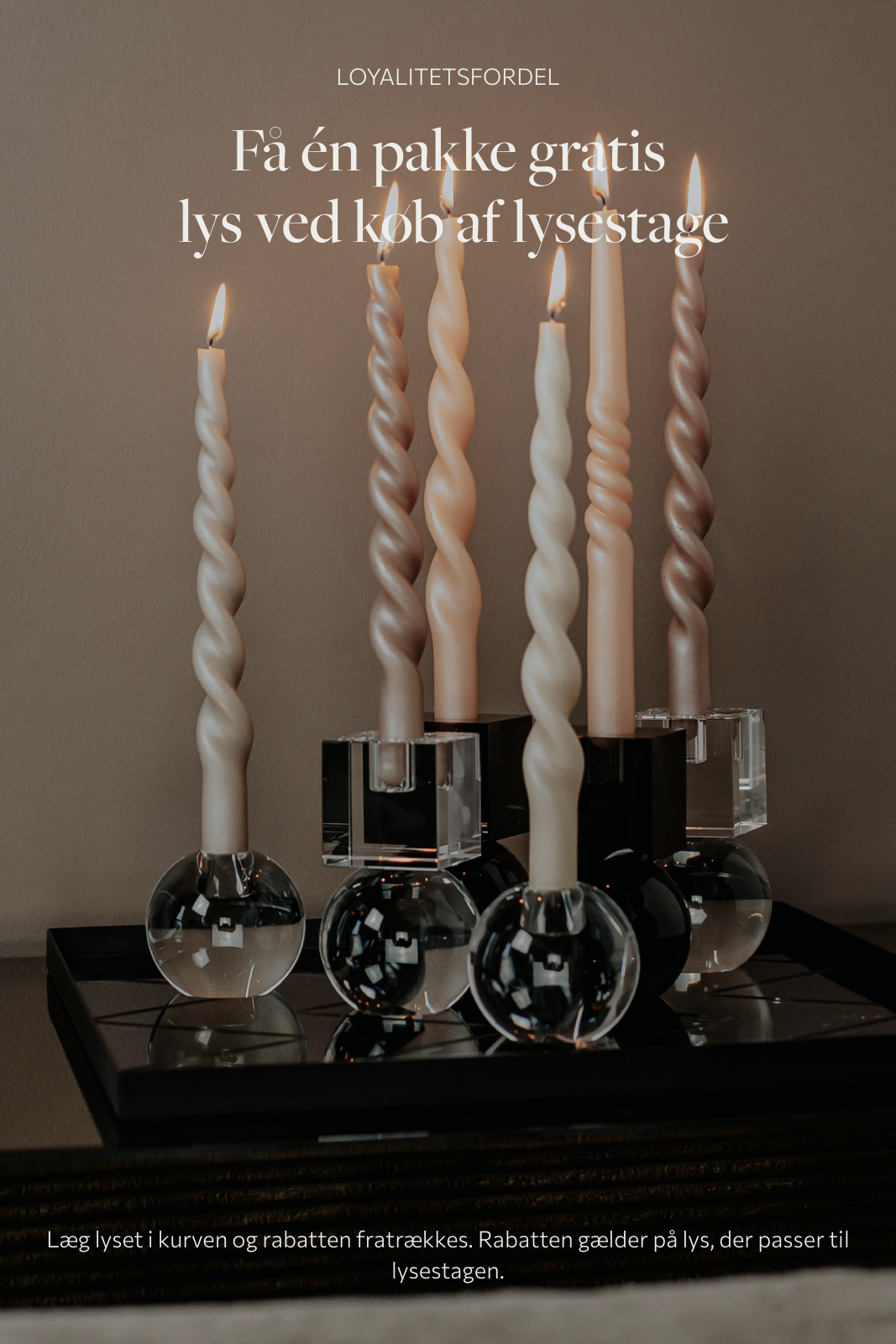 Loyalitetsfordel, få en pakke gratis lyse ved køb af lysestage. Billede af en masse lysestager med snoede lys, der står på en spejlbakke.