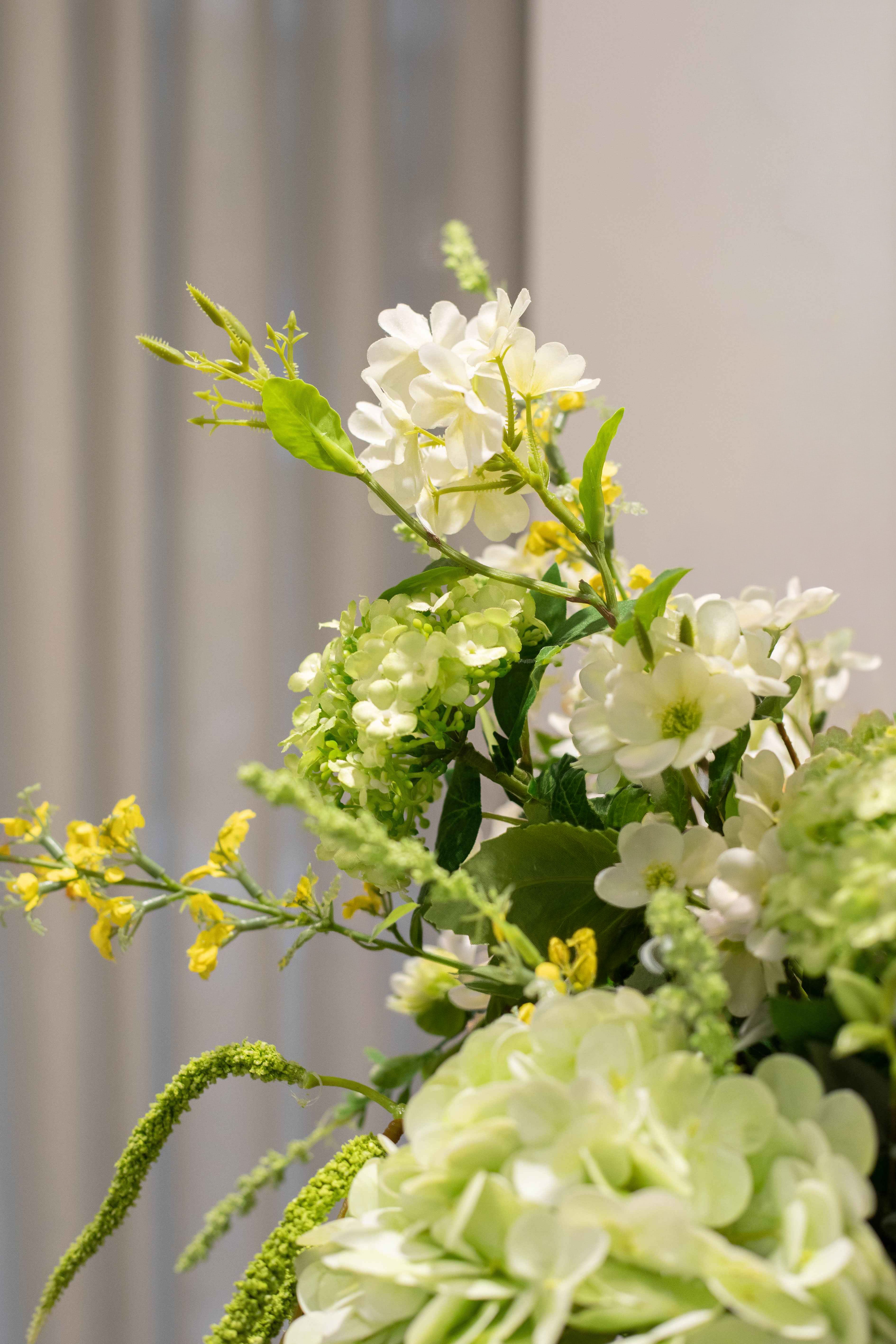 Nærbillede af buketten Luftig Romantik i hvide, grønne og lyse gule nuancer. 