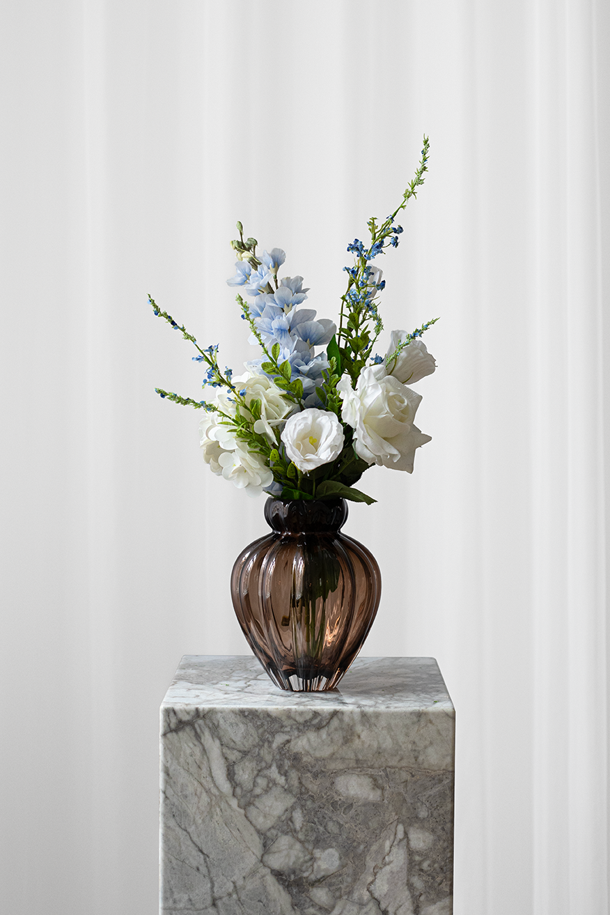 lille kunstig buket med en hvid rose, hvid hortensia og blå consolida blomst