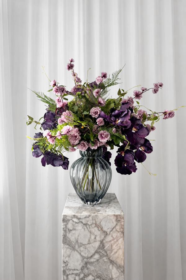 Overdådig buket i lilla nuancer stylet i en glasvase. Blomsterne er naturtro kunstige blomster fra Specktrum.