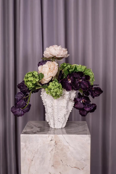 Kunstige blomster.
Buketten er stylet i Naya vasen.
Buketten indeholder:
2 x Purple Orchid (7 heads)
1 x Green Hydrangea branch
1 x White Anthurium 
1 x Green Hydrangea
2 x Cream Peony