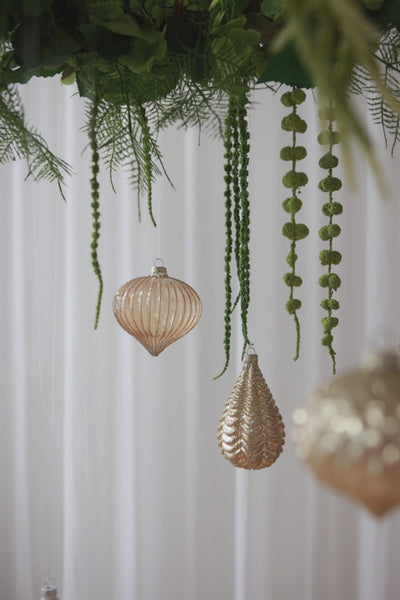 video af stor grøn krans af kunstige blomster, fra den hænger julekugler.