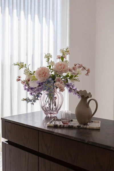 Stor kunstig men naturtro blomsterbuket i lyserøde og lilla nuancer