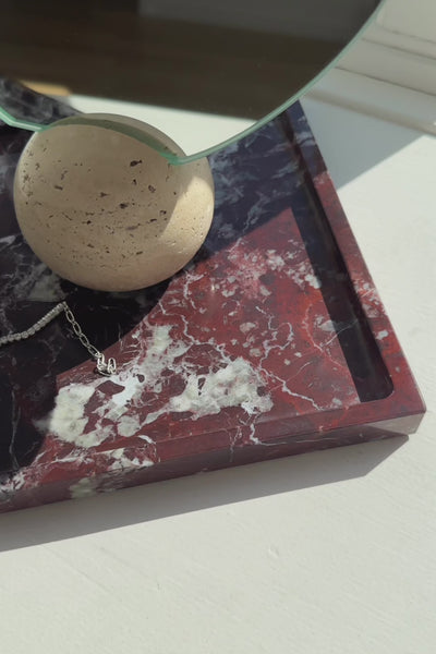 Video af phantom marmor bakke i farven glory, der står i en vindueskarm. På bakken står et bordspejl og en hvid nellie vase.