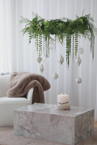 Video af stor grøn krans af kunstige blomster, fra den hænger julekugler.