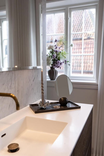 Phantom bakke i mørk marmor med hvide stængt. Stylet med Asta bordspejlet og Lea lysestagen.