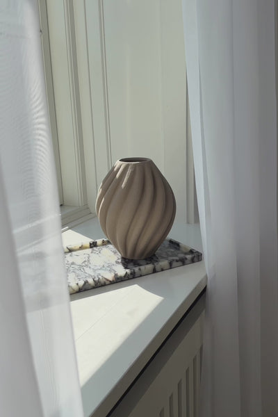 Video af phantom marmorbakke i farven halo, der står i en vindueskarm. På bakken står en brun keramikvase.