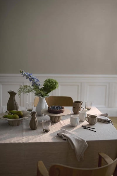 Nellie kopperne i hvid uden hank på smuk bordopdækning med resten af Nellie kollektionen i håndlavet keramik. 